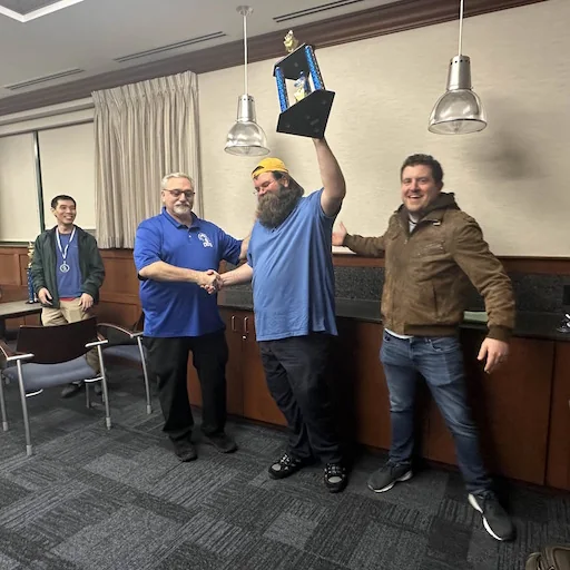 Matthew Freeman holding a chess championship trophy
